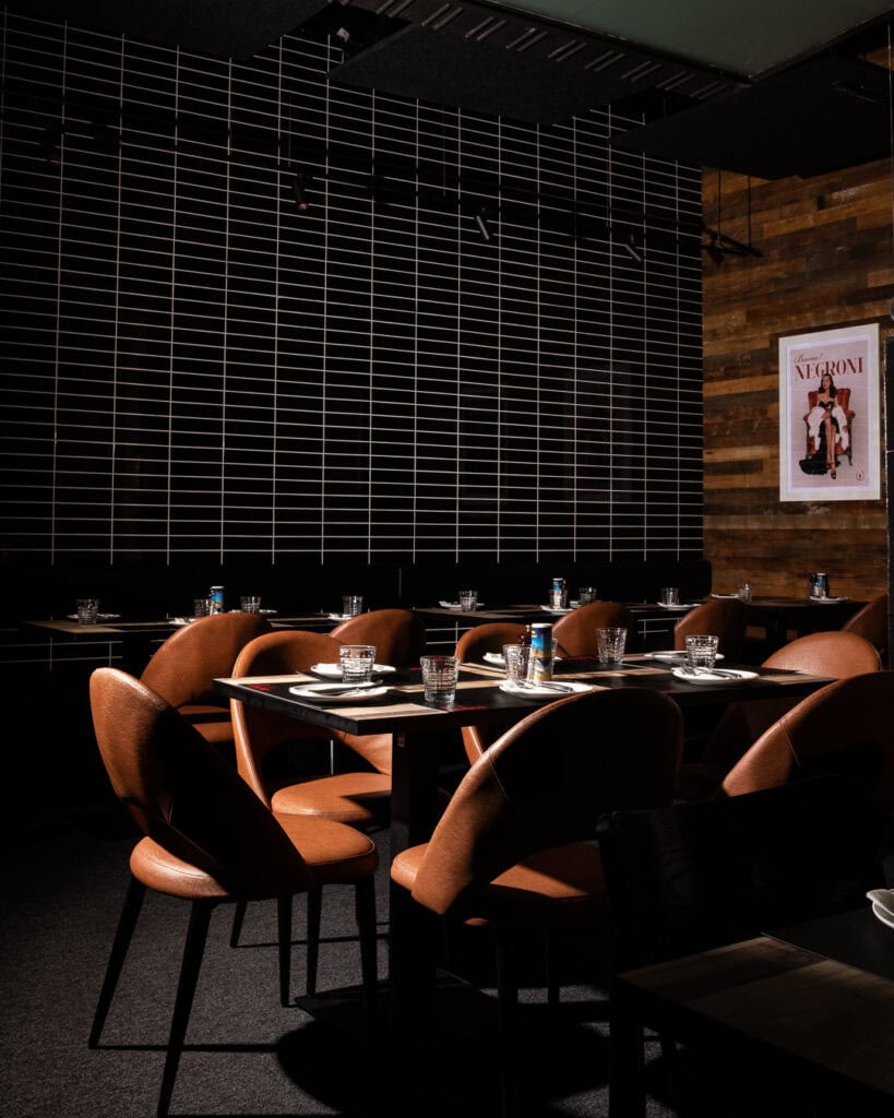 Modern restaurant interior with brown chairs and tables.