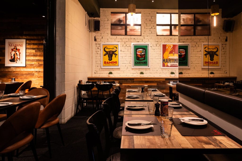 Cozy restaurant with vintage posters on walls.