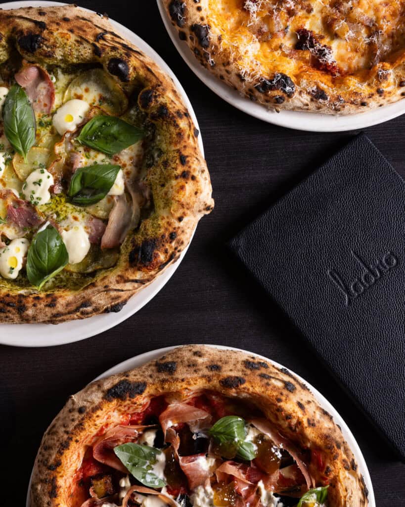 Three gourmet pizzas with various toppings.